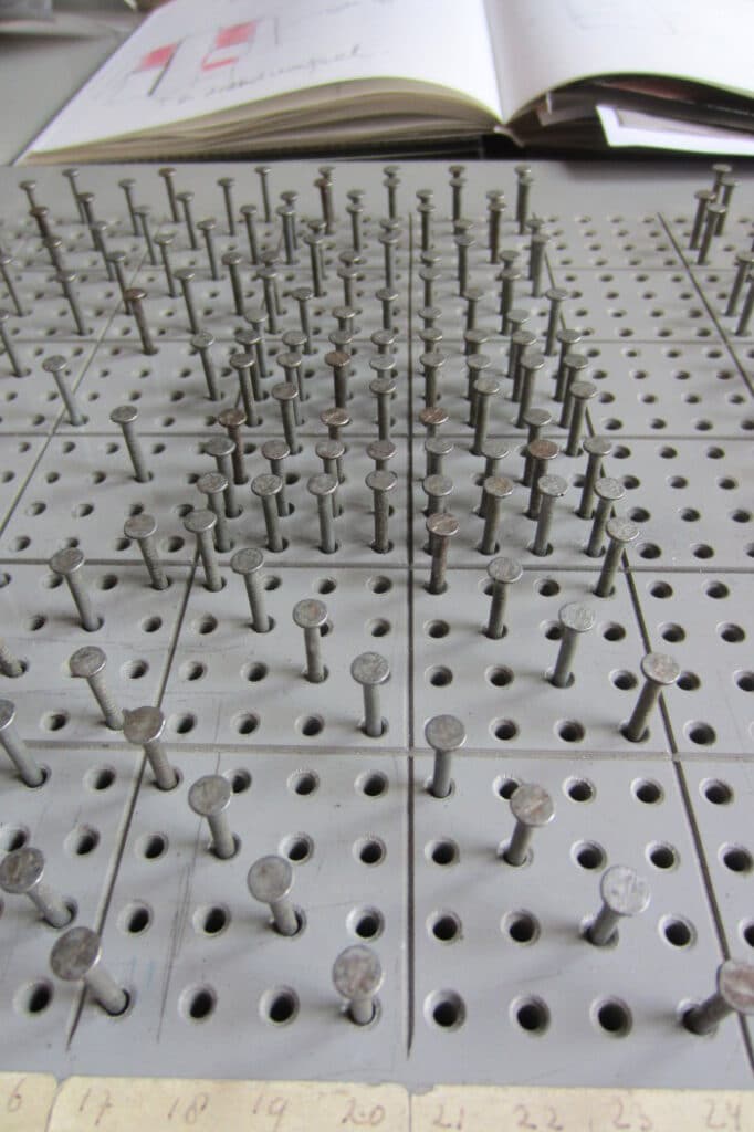 Marianne Kem - preparing loom pins in a certain pattern for weaving